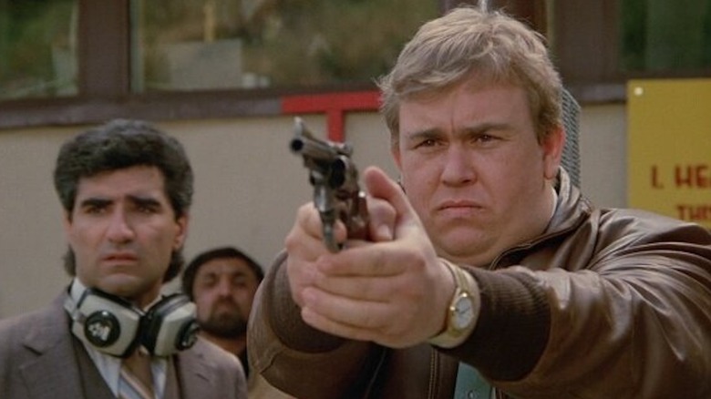 John Candy as Frank Dooley is packing heat as Eugene Levy as Norman Kane looks on in Armed and Dangerous