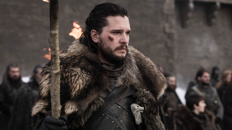 John Snow holds a flame with pieces on his cheek in the game of thrones
