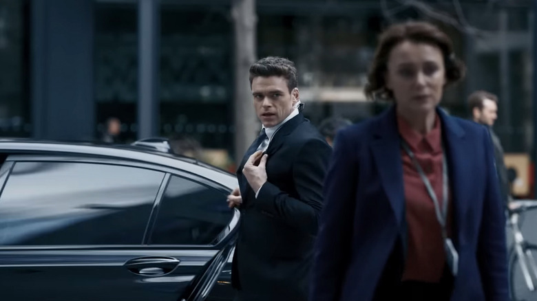 Richard Madden's David Budd watches as Keeley Hawes's Julia Montague walks away from a car in Bodyguard