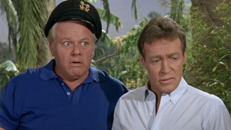 రస్సెల్ జాన్సన్ యొక్క ప్రొఫెసర్ రాయ్ హింక్లీ గిల్లిగాన్స్ ద్వీపంలో అలాన్ హేల్ జూనియర్ యొక్క కెప్టెన్ జోనాస్ గ్రంబీ పక్కన ఉన్నారు