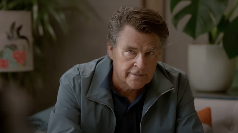 Ted McGinley as Derek sitting on a couch in Shrinking