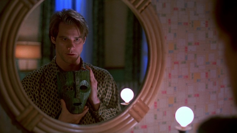 Stanley Ipkiss holding up a mask in a mirror in The Mask