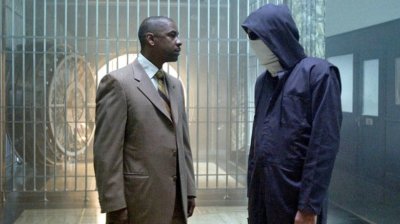 Hostage negotiator Keith Fraizer faces off against the masked bank robber Dalton Russell in the bank vault in Inside Man