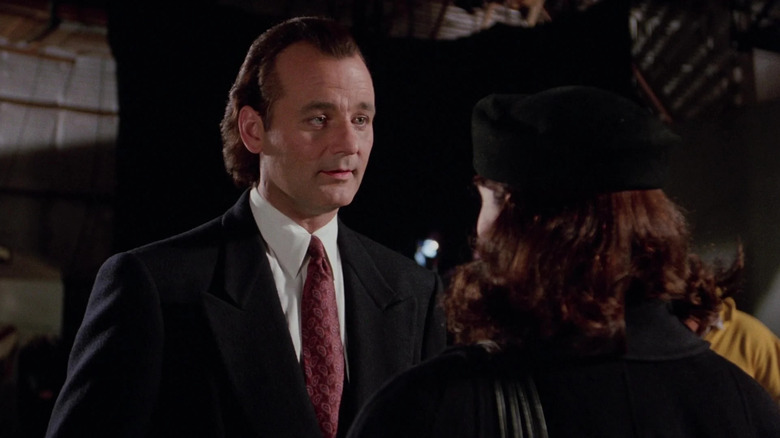 Frank Cross, looking smug, talks to his soon-to-be ex-girlfriend in Scrooged.