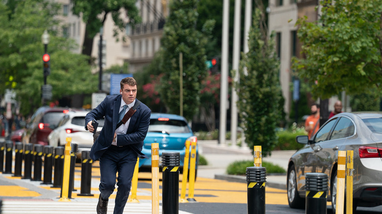Jake Baerington runs down the street with his phone in his hand in A House of Dynamite