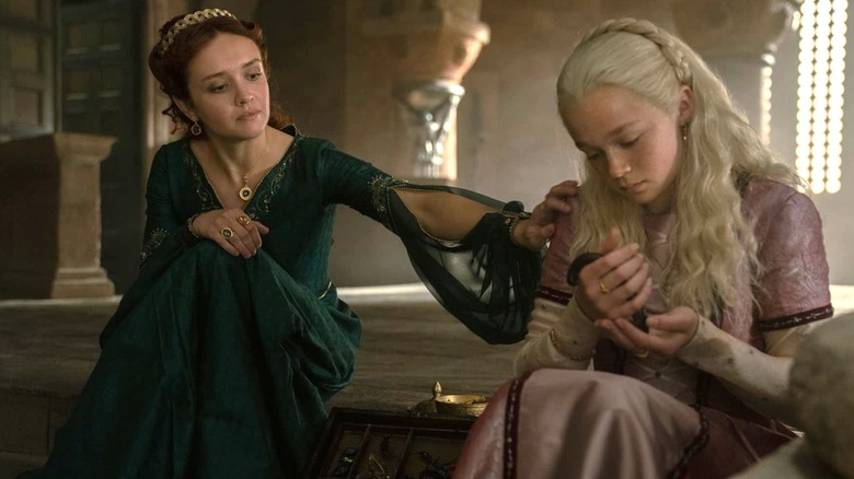 Olivia Cooke as Alicent Hightower touching the shoulder of Evie Allen as Helaena Targaryen in House of the Dragon