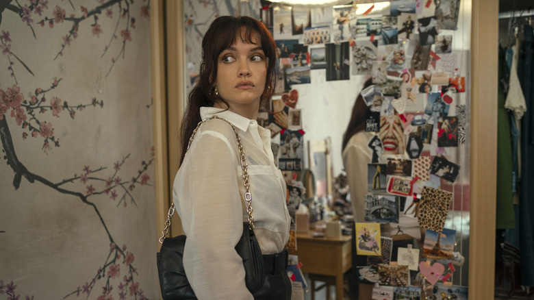 Cherry in front of a vanity covered in magazine cutouts looking behind her on The Girlfriend