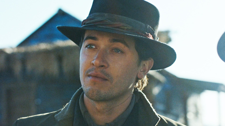 Tom Blyth's Henry McCarty/Billy the Kid stands outside in a town in Billy the Kid