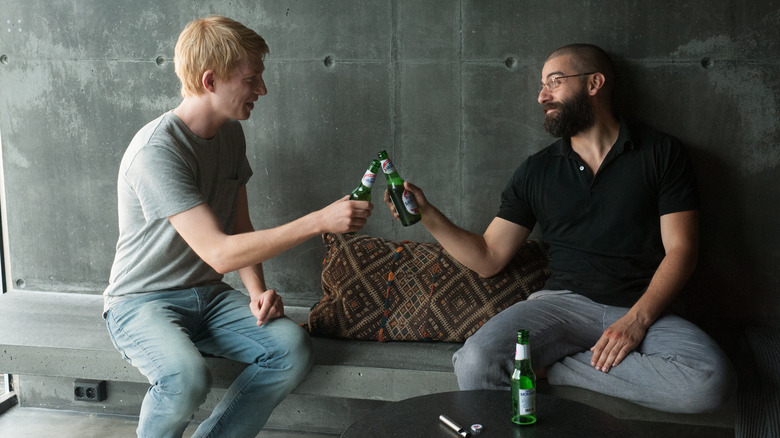 Oscar Isaac and Domhnall Gleeson clinking beers in Ex Machina