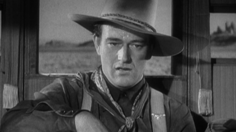 Henry by John Wayne looks directly, wearing haunted, in Stagecoach