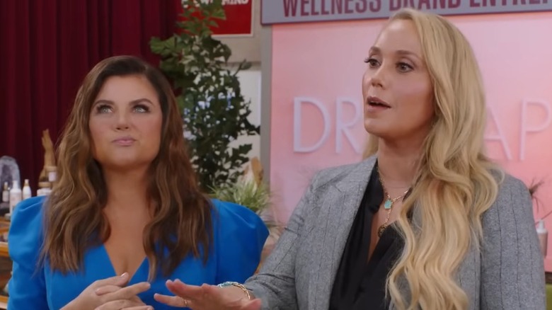 Kelly Kapowski (Tiffani Thiessen) thinking and Jessie Spano (Elizabeth Berkley) holding out her hand in the Saved by the Bell reboot