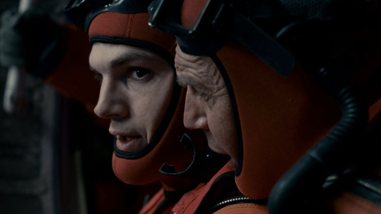 Kevin Costner's Ben Randall talks to Ashton Kutcher's Jake Fischer as he prepares to jump from a helicopter in The Guardian