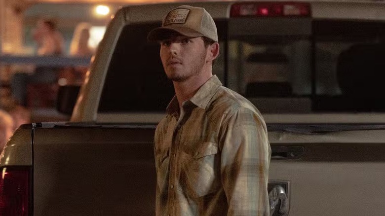Carter (Finn Little) standing next to a truck on 