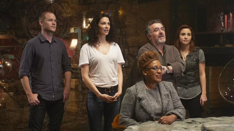 The core cast of the show gathers inside the titular space in Warehouse 13