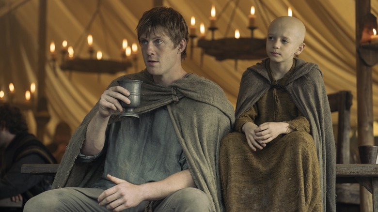 ఎ నైట్ ఆఫ్ సెవెన్ కింగ్‌డమ్స్‌లో గుడ్డు పక్కన కూర్చున్నప్పుడు డంక్ పానీయం పట్టుకుంది