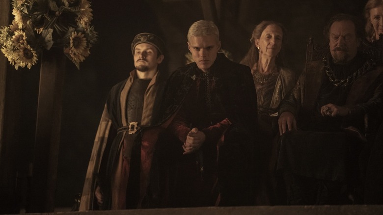 Aerion zit tegenover andere hovelingen in A Knight of the Seven Kingdoms