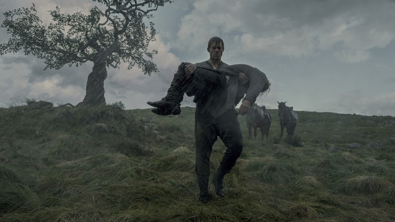 Peter Claffey as Ser Duncan the Tall standing in the rain and holding Danny Webb as the corpse of Ser Arlan in A Knight of the Seven Kingdoms
