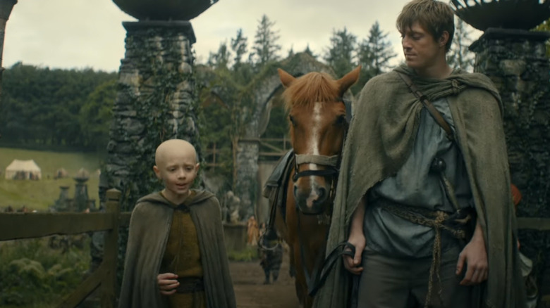 Peter Claffey as Ser Duncan and and Dexter Sol Ansell as Egg walking on a village road in A Knight of the Seven Kingdoms