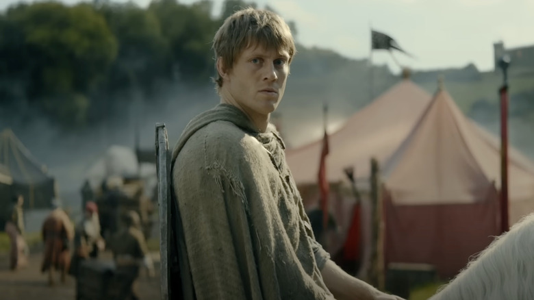 Peter Claffey as Ser Duncan sitting on a horse in a busy camp in A Knight of the Seven Kingdoms