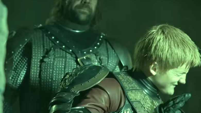 Game of Thrones, Jovari protects his eyes from the explosion of wildfire while watching hunting behind him