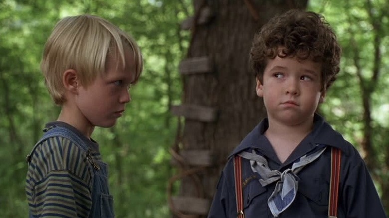 Dennis and one of his companions standing next to a treehouse in Dennis the Menace