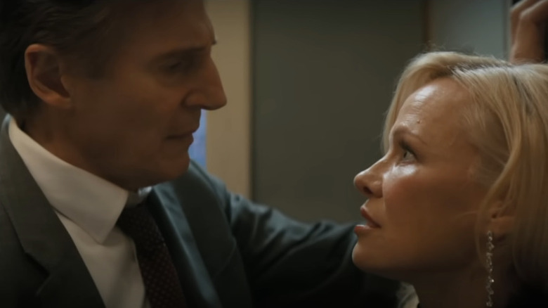 Frank Drebin Jr. (Liam Neeson) inches closer to Beth Davenport (Pamela Anderson) as they talk in The Naked Gun (2025)