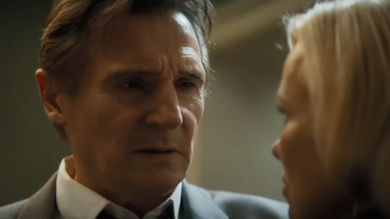 Frank Drebin Jr. (Liam Neeson) looks suspiciously at Beth Davenport (Pamela Anderson) in The Naked Gun (2025)