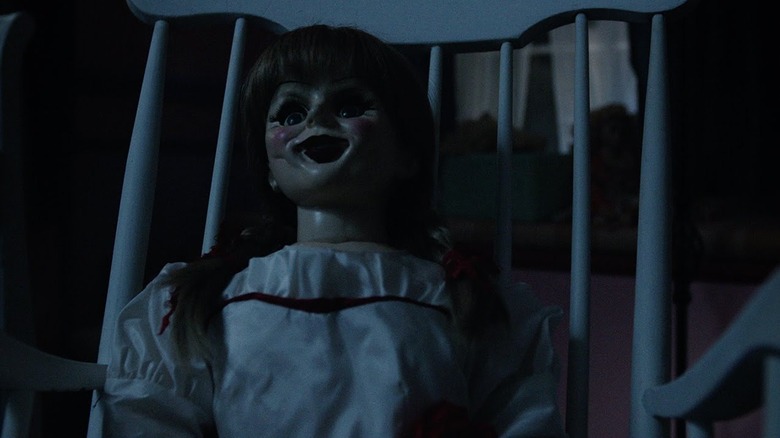 The Annabelle doll sitting in a rocking chair in Annabelle