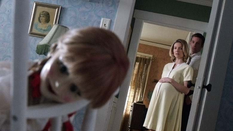 John and Mia staring at the Annabelle doll from the doorway in Annabelle