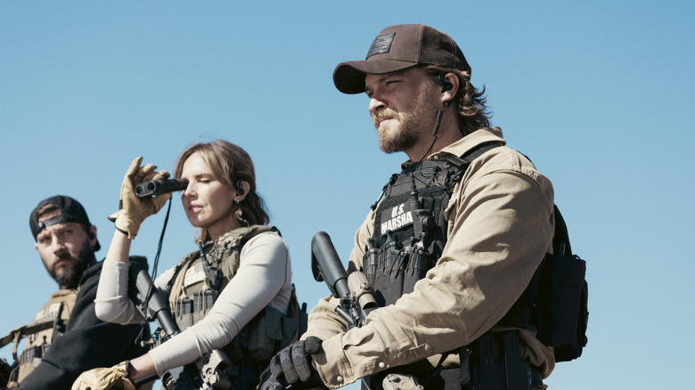 Logan Marshall-Green's Pete Calvin, Arielle Kebbels' Belle Skinner en Luke Grimes' Kayce Dutton worden gezien zittend op paarden tegen een blauwe lucht in Marhsals