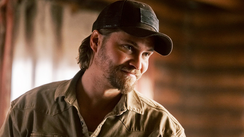 Luke Grimes' Kayce Dutton smiles as he stands in his home in Marshals