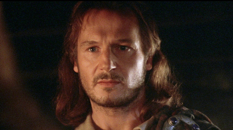 Liam Neeson as Rob Roy standing defiantly in Rob Roy (1995)