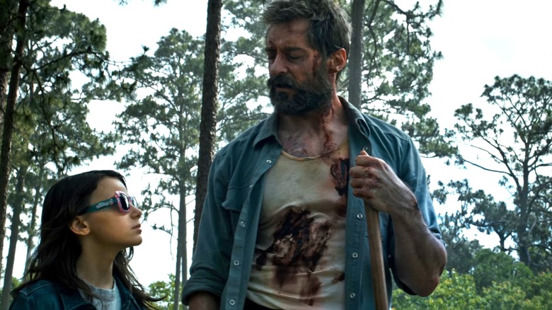 An injured Logan looks down at X-23 in Logan