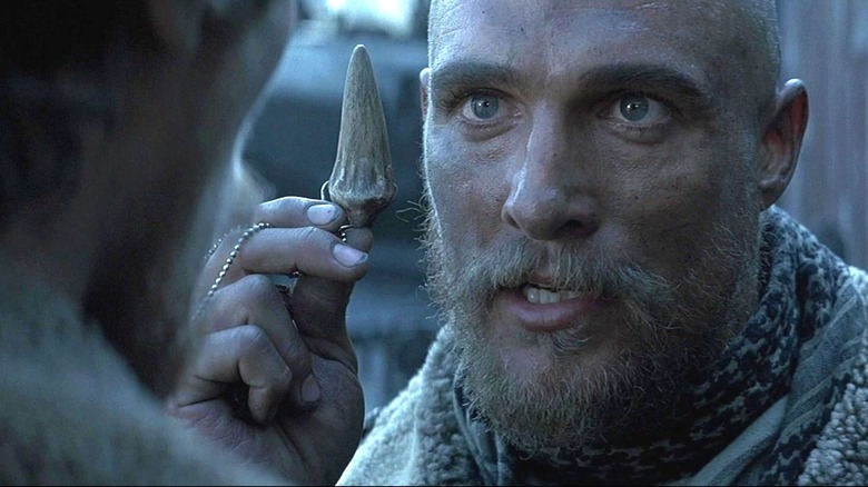 Denton Van Zan holding up a dragon's tooth in Reign of Fire