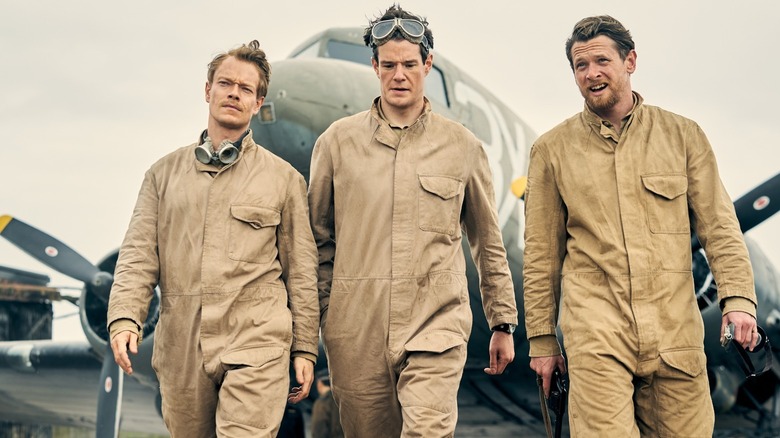 Alvay Allen, Kunoor Swindz, and Jack O'Connell in a miniser, walk away from the plane