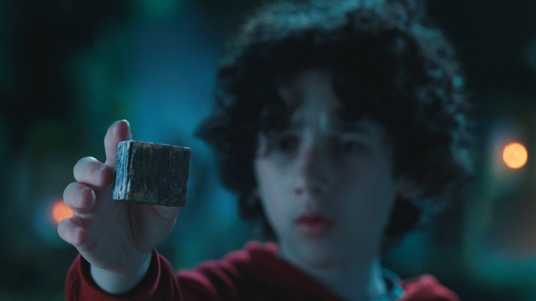 Sebastian Hansen's Henry holding up a cube in A Minecraft Movie