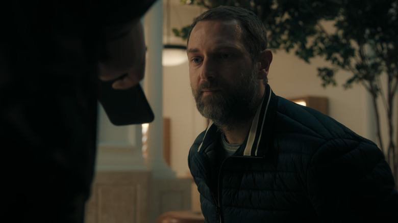 Admir Sehovic's Ilian Petrov sits looking at a phone being held by someone off-screen in iHostage