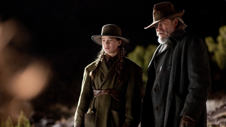 Production photo of True Grit (2010) showing Mattie Ross (Hailee Steinfeld) and Rooster Cogburn (Jeff Bridges) together