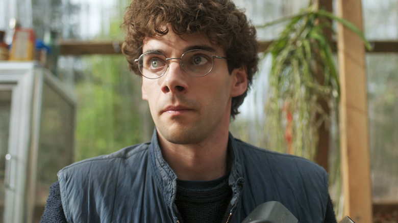 Álvaro Rico's Elmer looks off to the left as he sits in a greenhouse in The Gardener