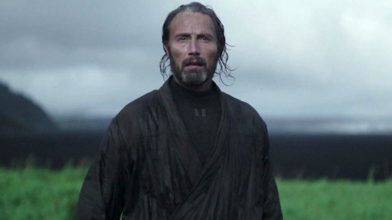 Galen Erso standing in a grassy field in Rogue One: A Star Wars Story