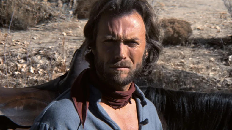 Josey Wales van Clint Eastwood loenst terwijl hij in het zonlicht staat in The Outlaw Josey Wales