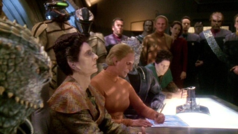 Berbagai pasukan Dominion menandatangani kontrak dengan Starfleet dan Bajoran berdiri di dekatnya di Star Trek: Deep Space Nine