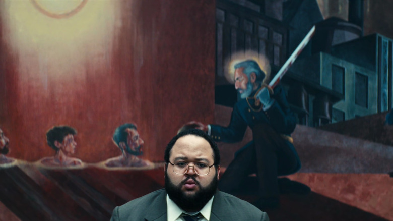Dylan sitting in front of a Lumon painting