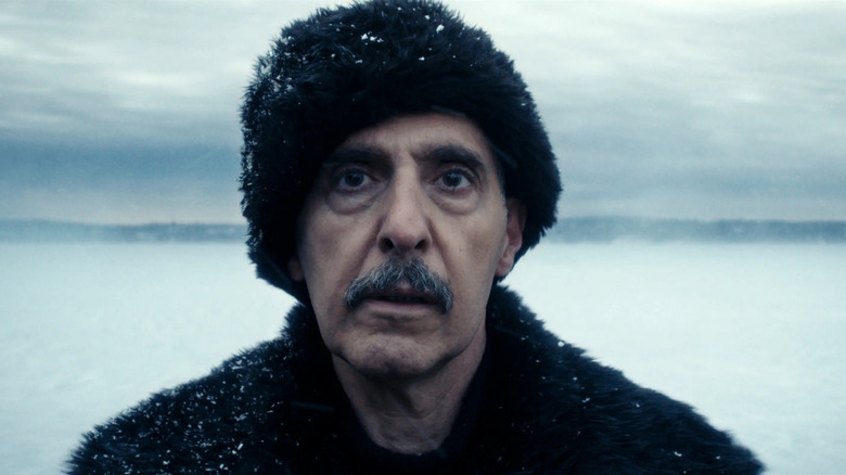 Irving wears a black winter cap and matching coat while standing in the snowy tundra in "Severance"