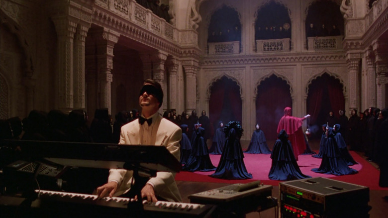 Nick plays the piano while blindfolded as an occult ritual involved several masked people is performed behind his back in "Eyes Wide Shut"