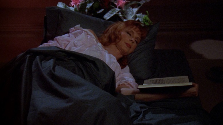 Beverly Crusher in bed asleep with a book on Star Trek: The Next Generation