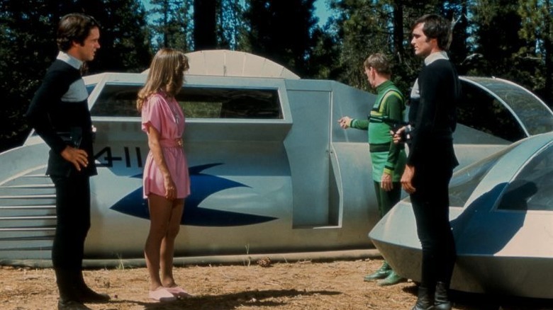 Jessica 6, Logan, Francis 7, and a friend standing next to a futuristic vehicle in Logan's Run
