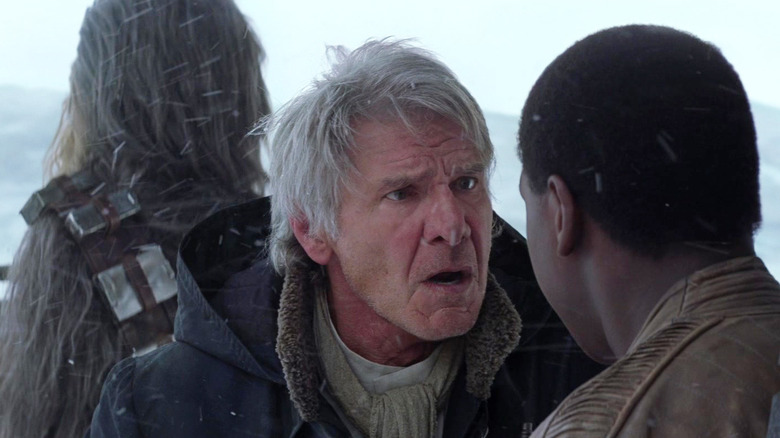Han looking dismayed at Finn with Chewbacca standing behind him in Star Wars: The Force Awakens