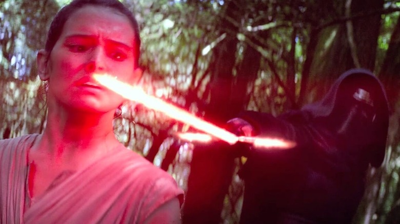 ஸ்டார் வார்ஸ்: தி ஃபோர்ஸ் அவேக்கன்ஸ் படத்தில் டெய்ஸி ரிட்லி ரேயாக ஆடம் டிரைவருடன் கைலோ ரென் என்ற பாத்திரத்தில் தனது லைட்சேபரை முகத்தில் பிடித்துக் கொள்கிறார்.