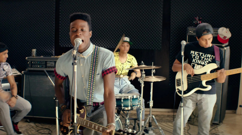 Malcolm singing at a mic with his punk band in the movie Dope